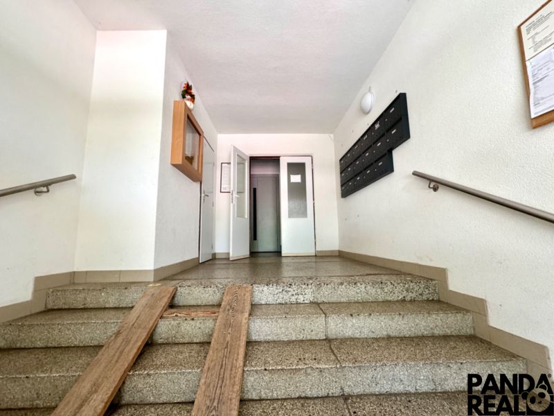 The entrance hall in an apartment building with mailboxes and an elevator.