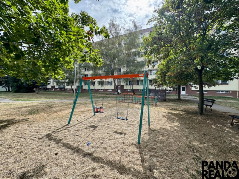 A playground with swings and greenery in the Topoľčany area near a 1-bedroom apartment.