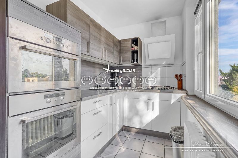 A kitchen with modern appliances and a window in a 2-room apartment.