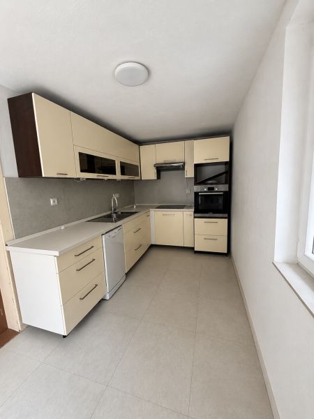 A kitchen in a family house with a cream-colored kitchen unit and built-in appliances.