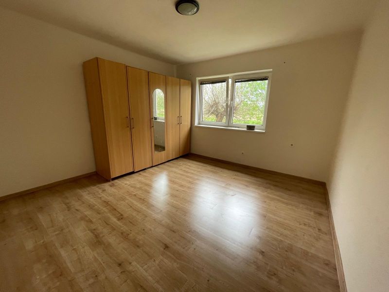A room with a wooden floor design and a built-in wardrobe in a family house.