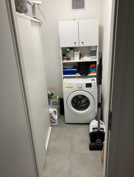 Laundry room with a washing machine and storage cabinets in a 3-room apartment.