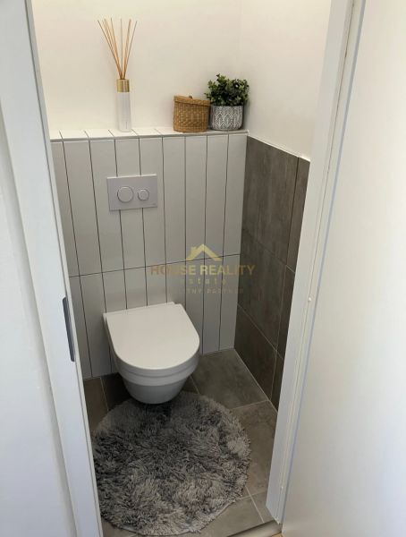 Bathroom in a 3-room apartment with storage space and decoration on the shelf.
