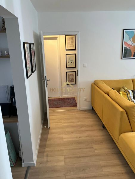 Light wood-effect flooring and a yellow sofa in a 3-room apartment.