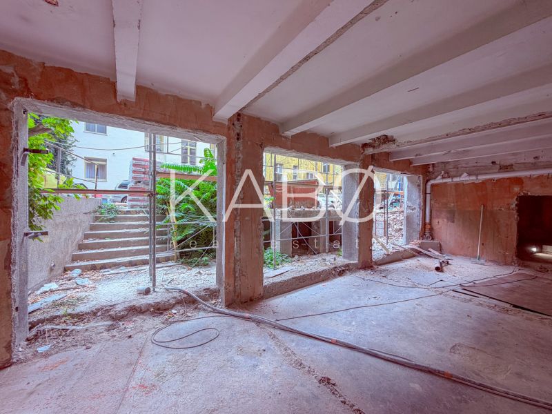 Renovation of commercial spaces with open walls and a view of stairs and greenery.