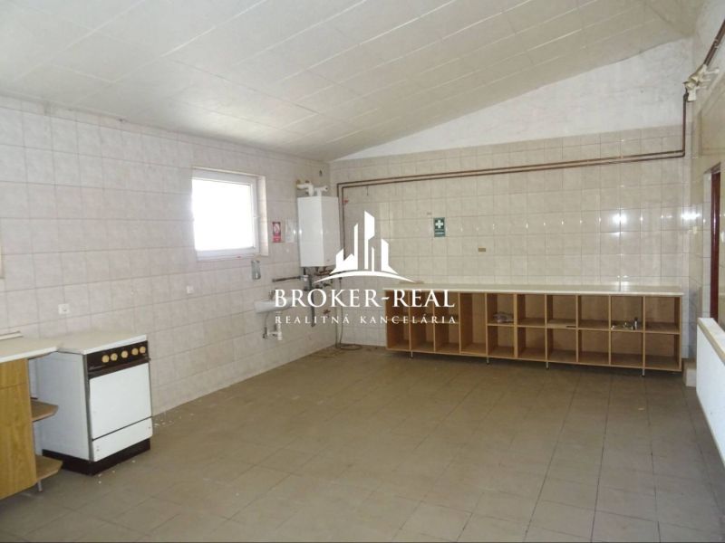 Interior with kitchen area, white tiles, and storage spaces in warehouses and halls.