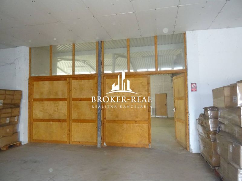 In warehouses and halls with wooden doors and pallets of products.