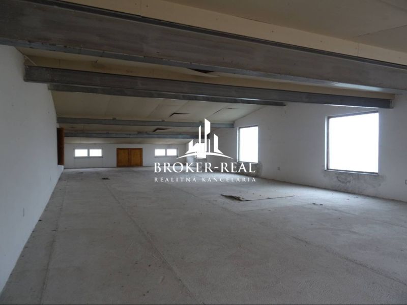 Spacious room of warehouses and halls with windows on a white wall and steel beams.