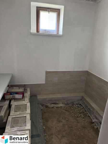 Interior of a family house with a window and sanded floor, preparation for tiling.