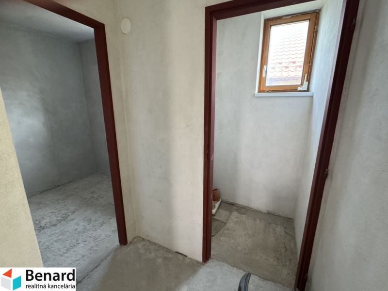 In the family house, there are two rooms with concrete floors and a small window.