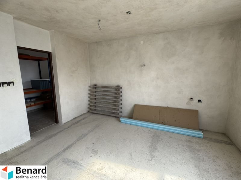 Interior of a family house with unfinished walls and floor, with materials on the floor.