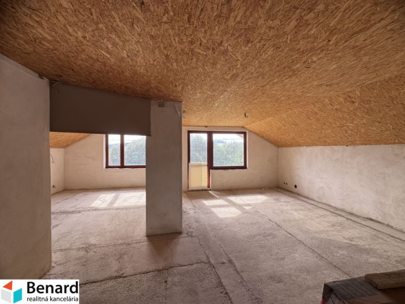Attic space in a family house with large windows and a view.