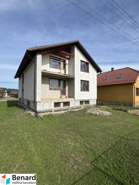 A family house in Plavnica with a green lawn and a partially finished facade.