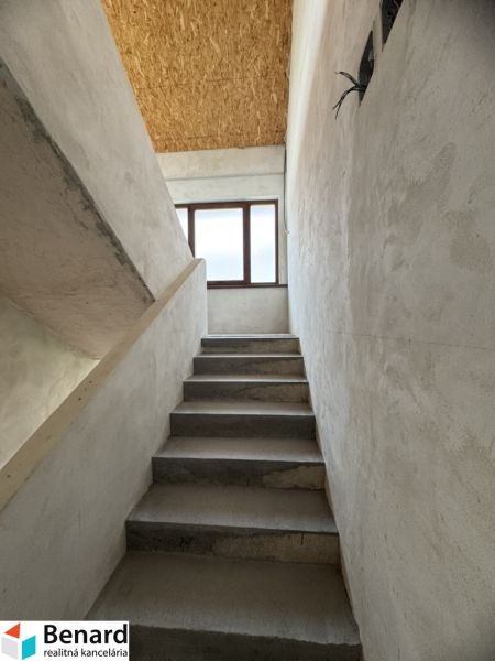 Concrete staircase leads to the window, OSB board ceiling, Family house.