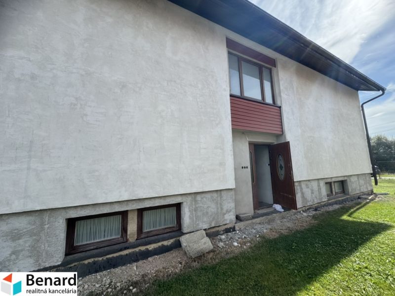 A family house in Plavnica with light plaster and wooden windows on the ground floor.