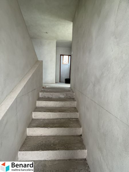 Concrete stairs leading to the upper floor in a family house with plastered walls.