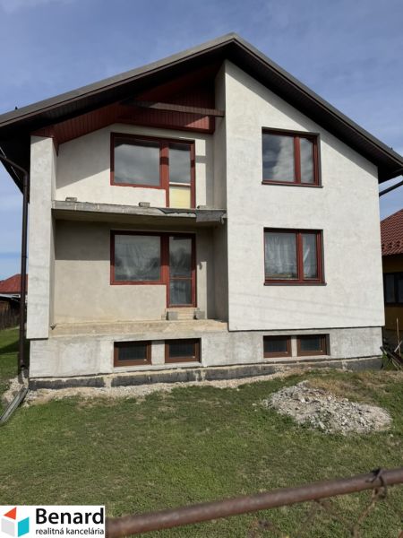 A family house in Plavnica with a simple facade and new windows, with a grassy plot.