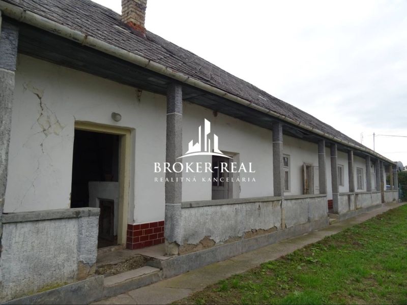 A family house in Černochov with a columned arcade and slightly damaged plaster.