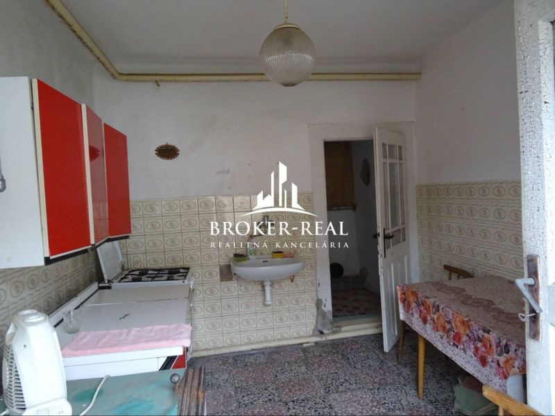 A kitchen in a family house with patterned tiles and red cabinets.