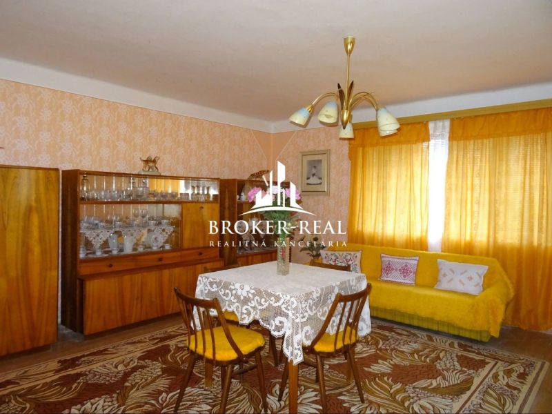 Living room in a family house with retro furniture and yellow curtains.