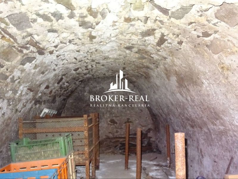 A stone cellar in a family house in Černochov with wooden shelves.