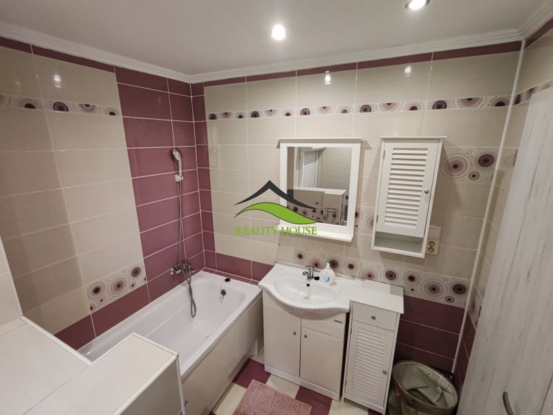 A bathroom with a shower bath and white furniture in a 3-room apartment.