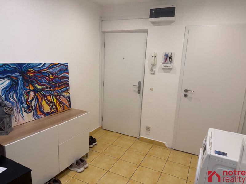 A bright hallway in a 2-room apartment with a colorful painting on the dresser.