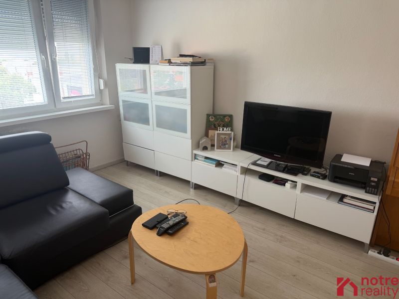 Living room in a two-room apartment with a wooden decor floor and modern furniture.