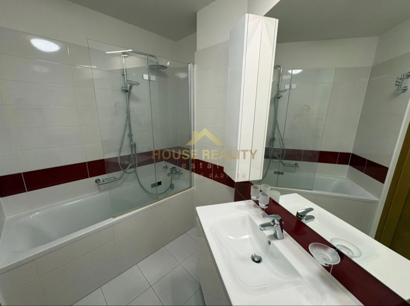 A bathroom with a bathtub and a showerhead in a 3-room apartment.