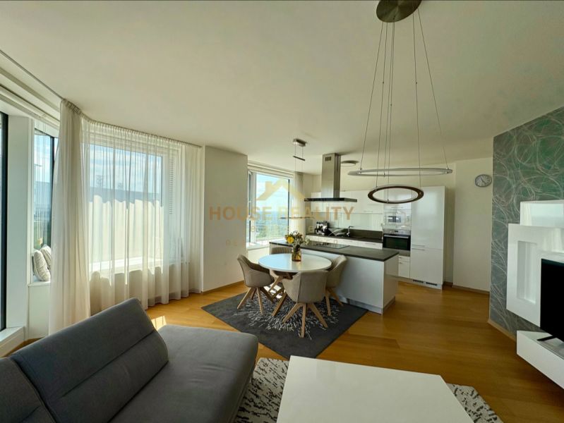 Living room of a three-room apartment with a wooden decor floor and a kitchenette.