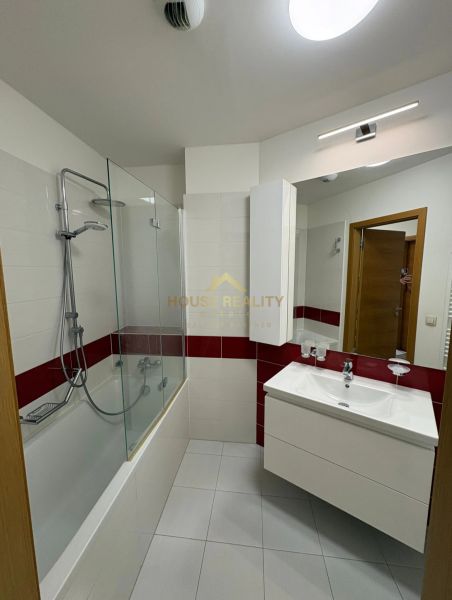 Bathroom with a bathtub, mirror, and sink in a 3-room apartment.