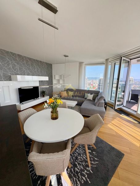 A living room in a three-room apartment with a round table and a floor with a wooden decor.