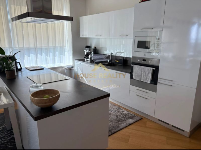 A kitchen in a 3-room apartment with white cabinets and a wooden decor floor.