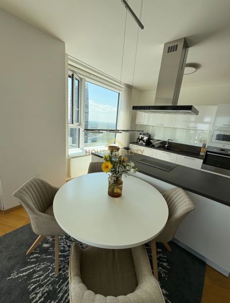A kitchen in a 3-room apartment with a round table and a view, wooden decor flooring.