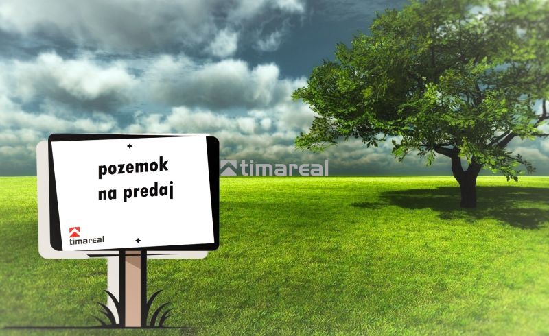 The board announces the sale of land, a green lawn next to a tree is displayed.