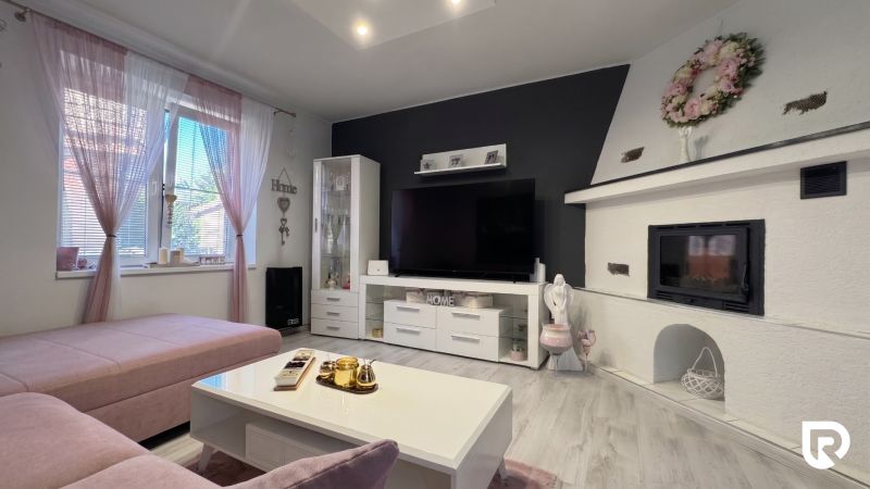 Living room in a family house with a fireplace, sofa, and decorative details.