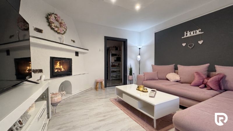 Living room in a family house with a fireplace, sofa, and decorative elements.