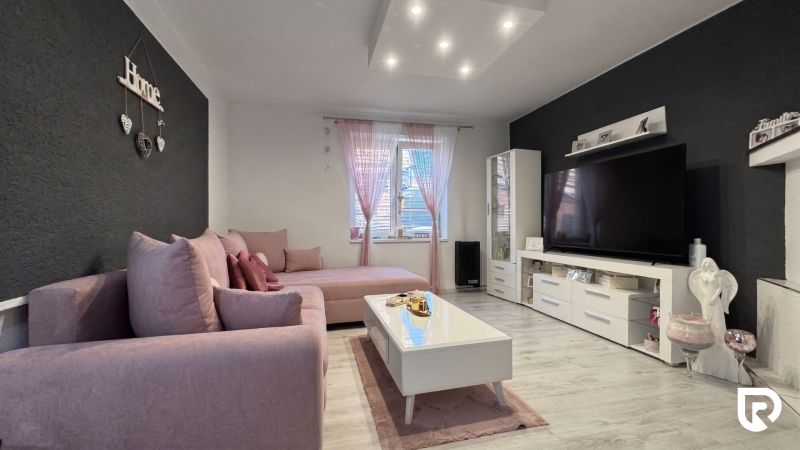 Living room in a family house with a pink sofa and decorations.