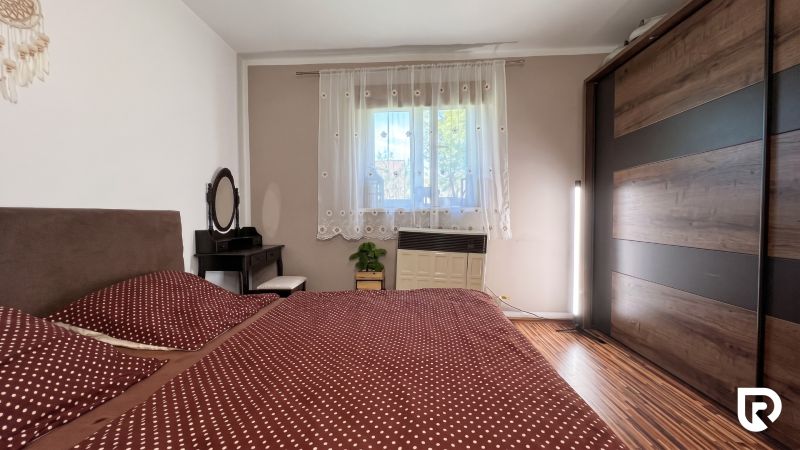 A bedroom in a family house with decorative curtains and a wooden decor floor.