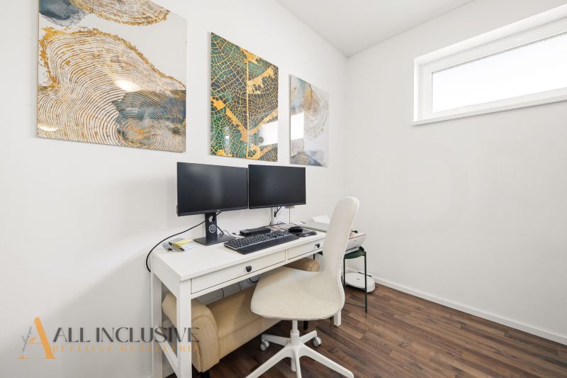 A study in a 3-room apartment with a desk, two monitors, and a floor with a wooden decor.