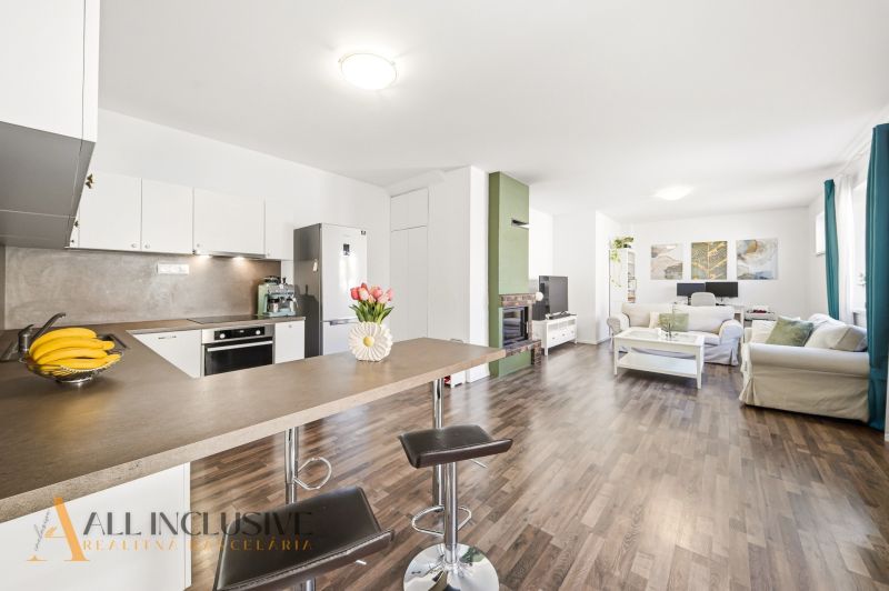 Living room with kitchen in a 3-room apartment, wooden decor flooring, light decoration.