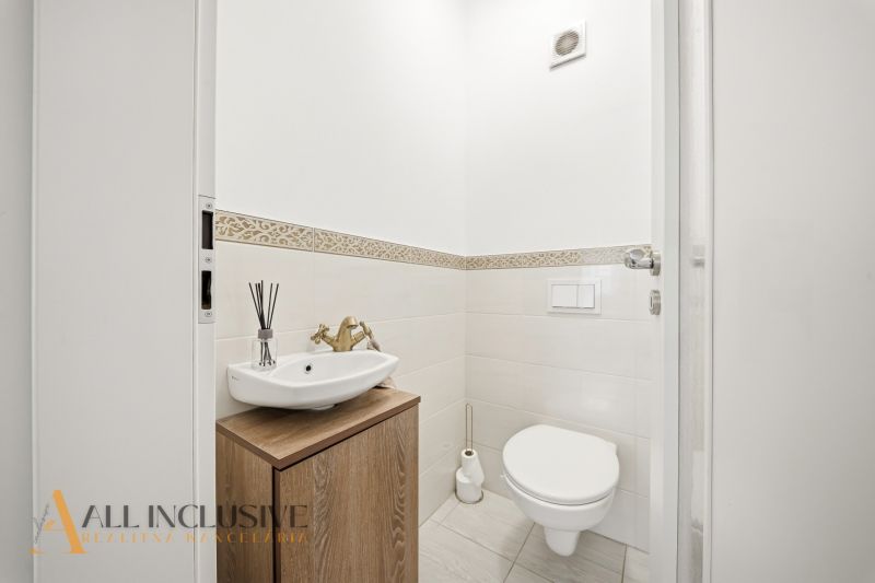 A bathroom in a 3-room apartment with a sink and a toilet, tiles with a decorative pattern.
