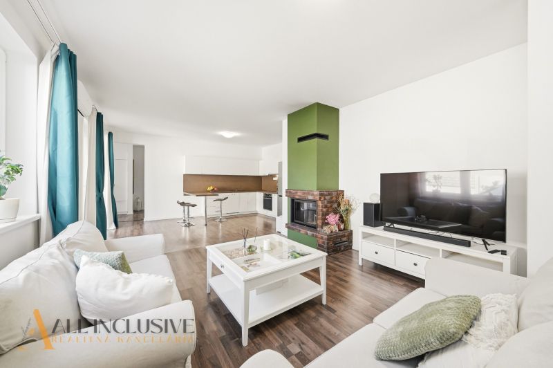 Living room in a 3-room apartment with a fireplace and a wooden decor floor.