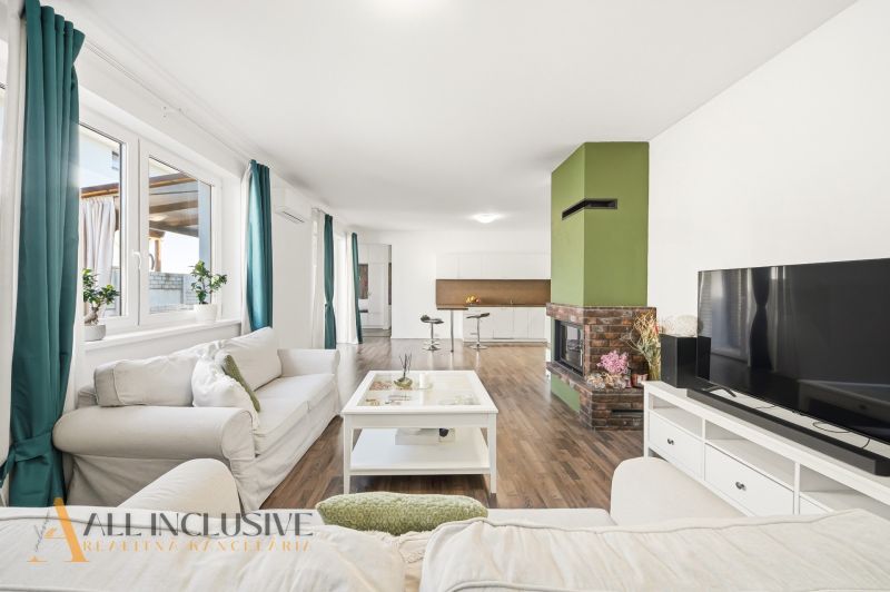 Living room in a three-room apartment with a wooden decor floor and a fireplace.