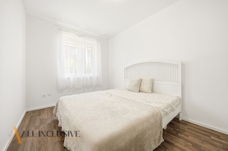 Bright bedroom in a 3-room apartment with a bed and wood-decor flooring.