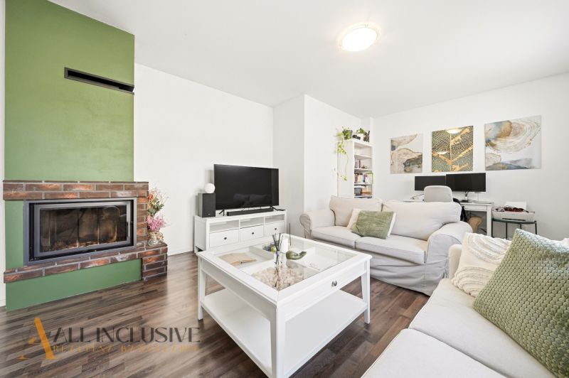 A bright living room in a 3-room apartment with a fireplace and a wooden decor floor.
