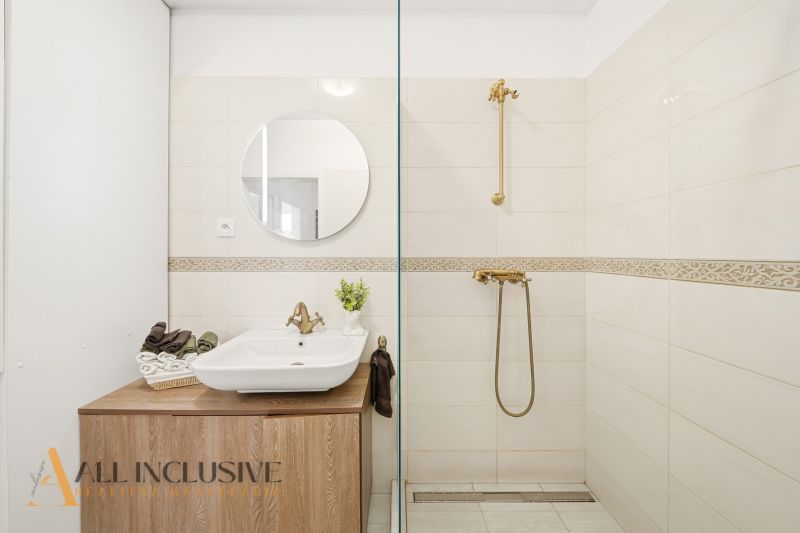 A bathroom in a 3-room apartment with colorful tiles and a mirror above the sink.