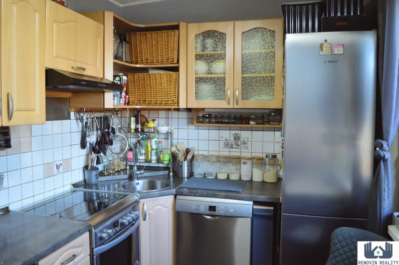 A kitchen in a 3-room apartment with built-in appliances and storage solutions.