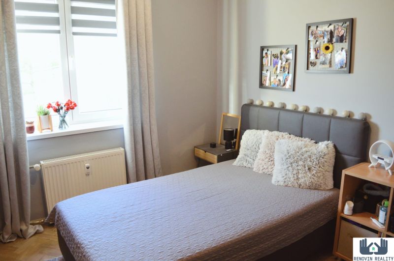 Bedroom in a 3-room apartment with a bed and decorative pillows.