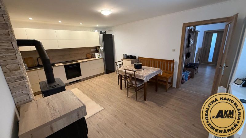 Kitchen and dining room with a fireplace, long table, wooden decor flooring, family house.